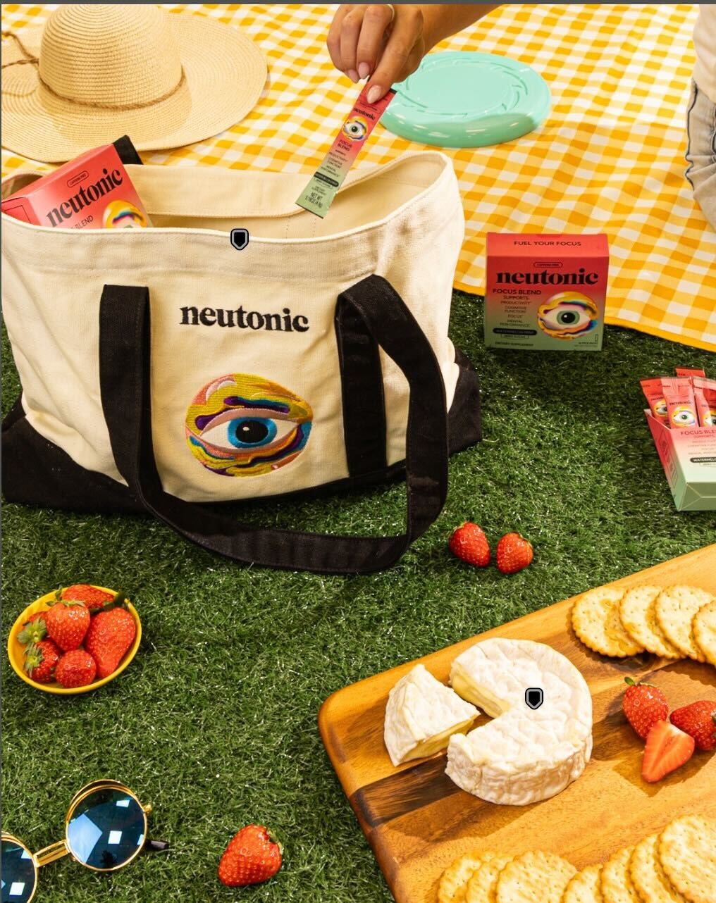 Canvas tote bag with black straps and colorful eye design, filled with nootropics boxes on a picnic blanket. - Neutonic - Tote Bag