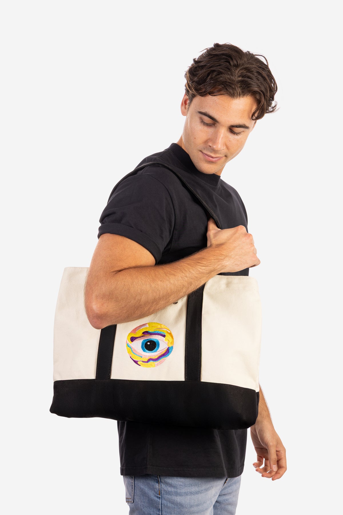 Canvas tote bag with black handles and nootropics eye logo on beige fabric, worn by man. - Neutonic - Tote Bag