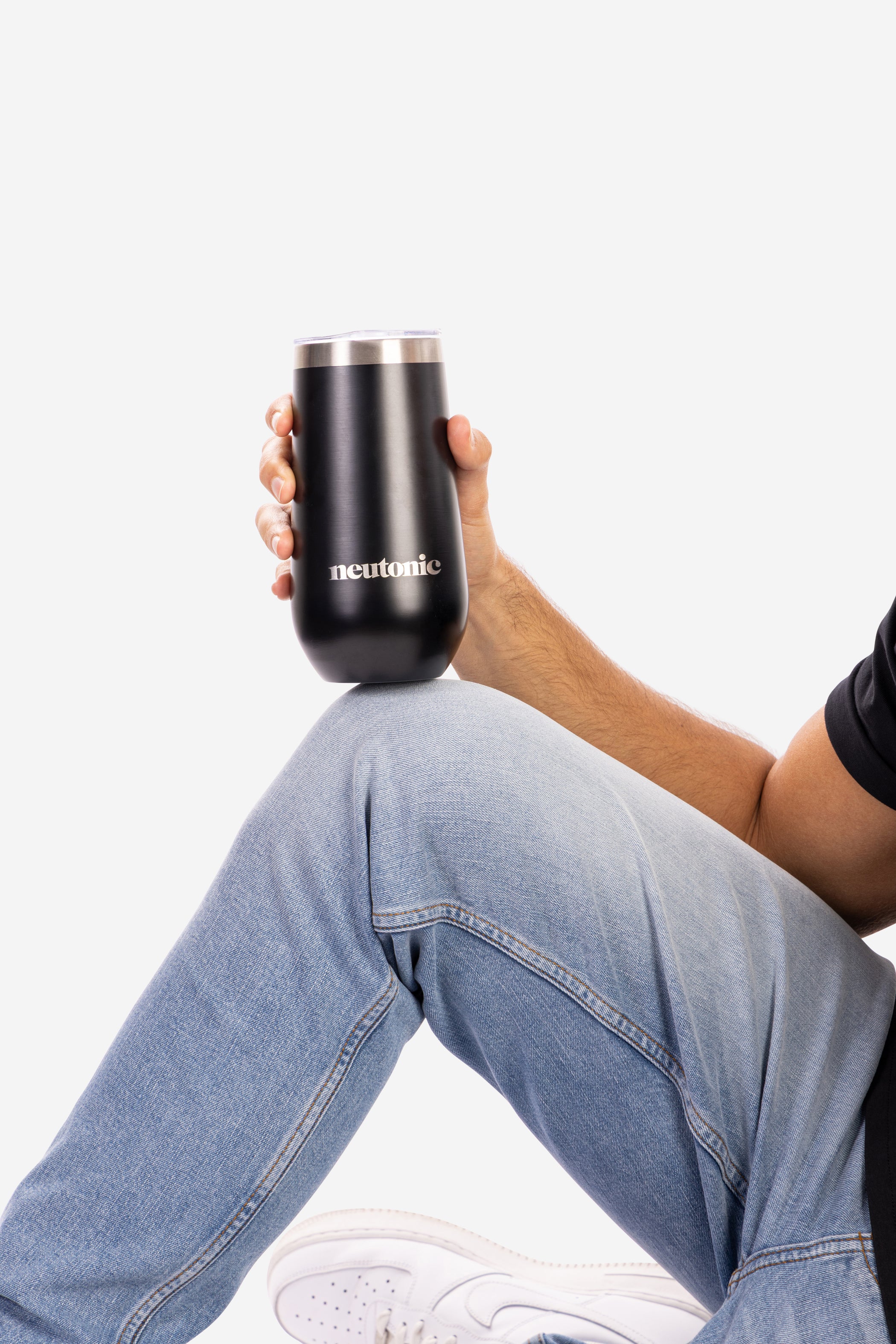 Black stainless steel tumbler with nootropics logo held by person wearing light blue jeans and black shirt. - Neutonic - Tumbler
