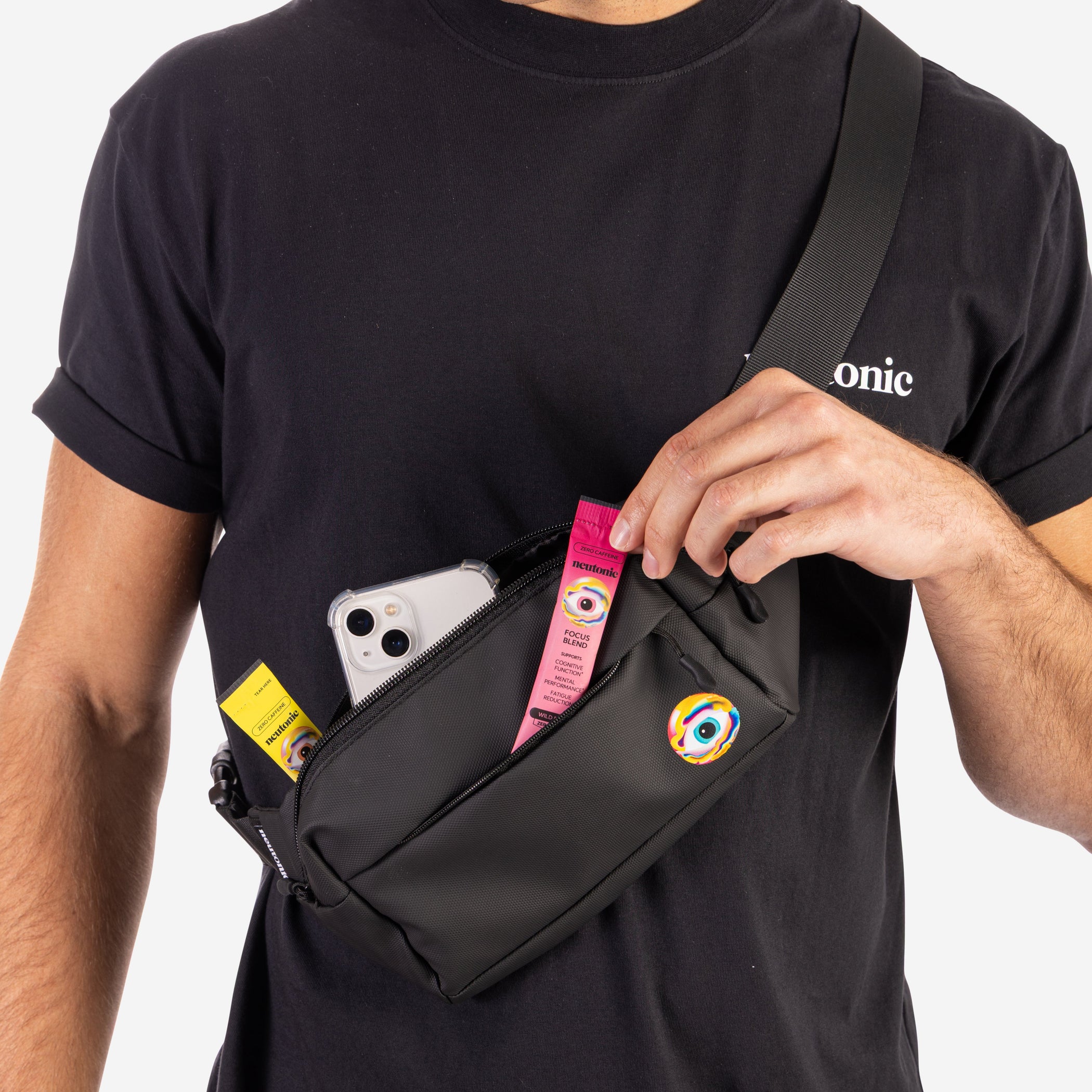 Black side bag worn crossbody with visible pink nootropics tube and white smartphone inside pocket. - Neutonic - Side Bag