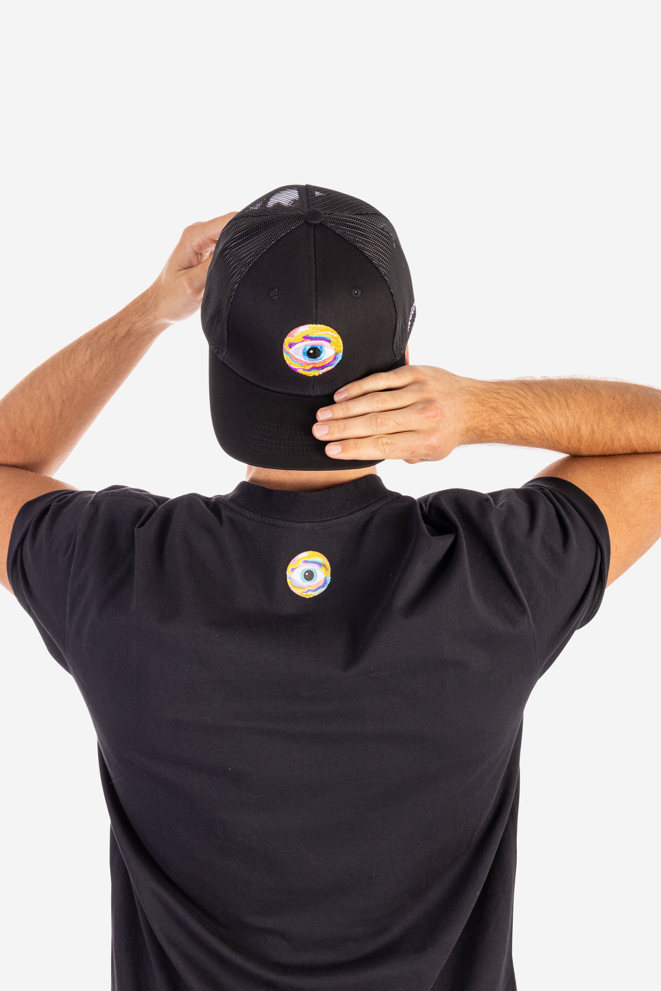 Black trucker cap with colorful eye design, worn with matching black shirt featuring smaller eye logo, highlighting. - Neutonic - Trucker Cap - Eye